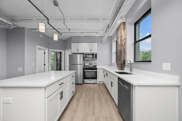 a large kitchen with a stove and refrigerator