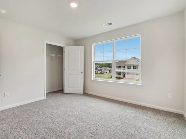 a view of a big room with windows and chandelier fan