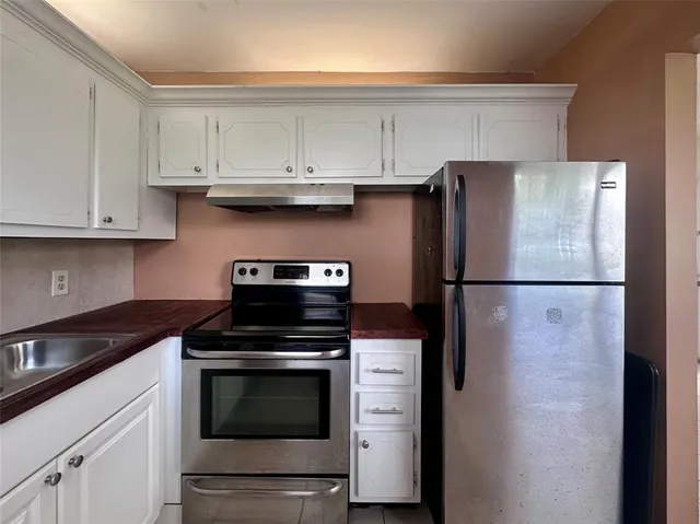 a kitchen with cabinets and stainless steel appliances