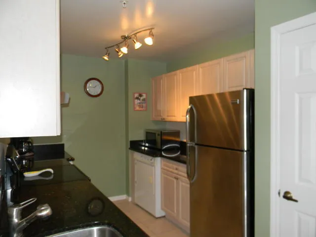 a kitchen with a refrigerator and a stove top oven