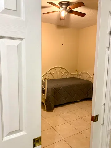 a bedroom with a bed and ceiling fan