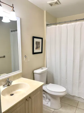 a bathroom with a sink a toilet and shower curtain