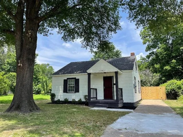 a front view of a house with a garden and yard