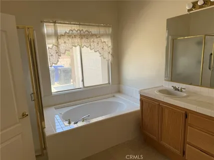 a bathroom with a tub sink and mirror
