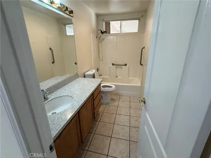 a bathroom with a granite countertop sink a toilet and shower