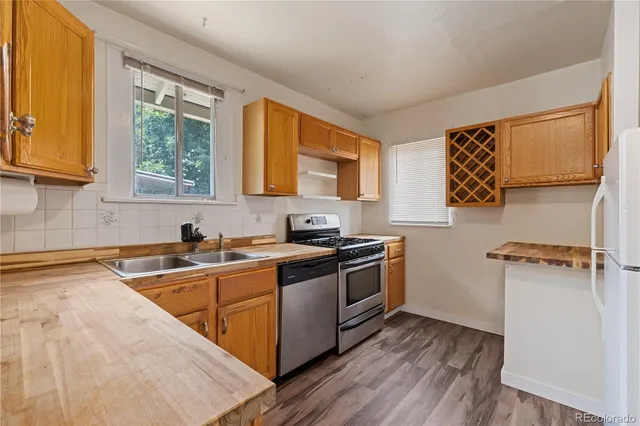 a kitchen with a sink wooden floor and a stove top oven