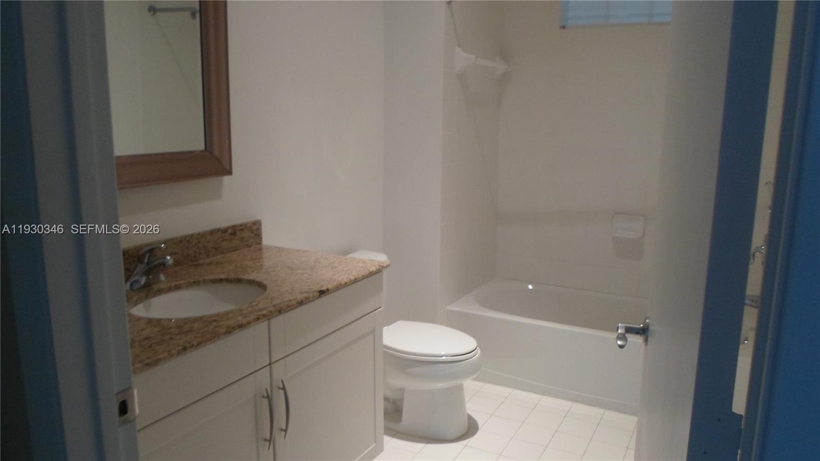 7275 Southwest 90th Way, Unit G 611 Miami, FL 33156 - Photo 12 of 56 a bathroom with a granite countertop toilet a sink and mirror