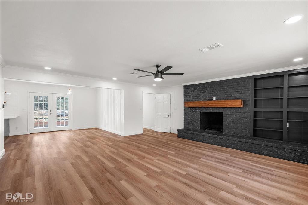 4136 Pines Road Shreveport, LA 71119 - Photo 17 of 38 Unfurnished living room featuring a fireplace, french doors, light wood-style floors, recessed lighting, and built in features