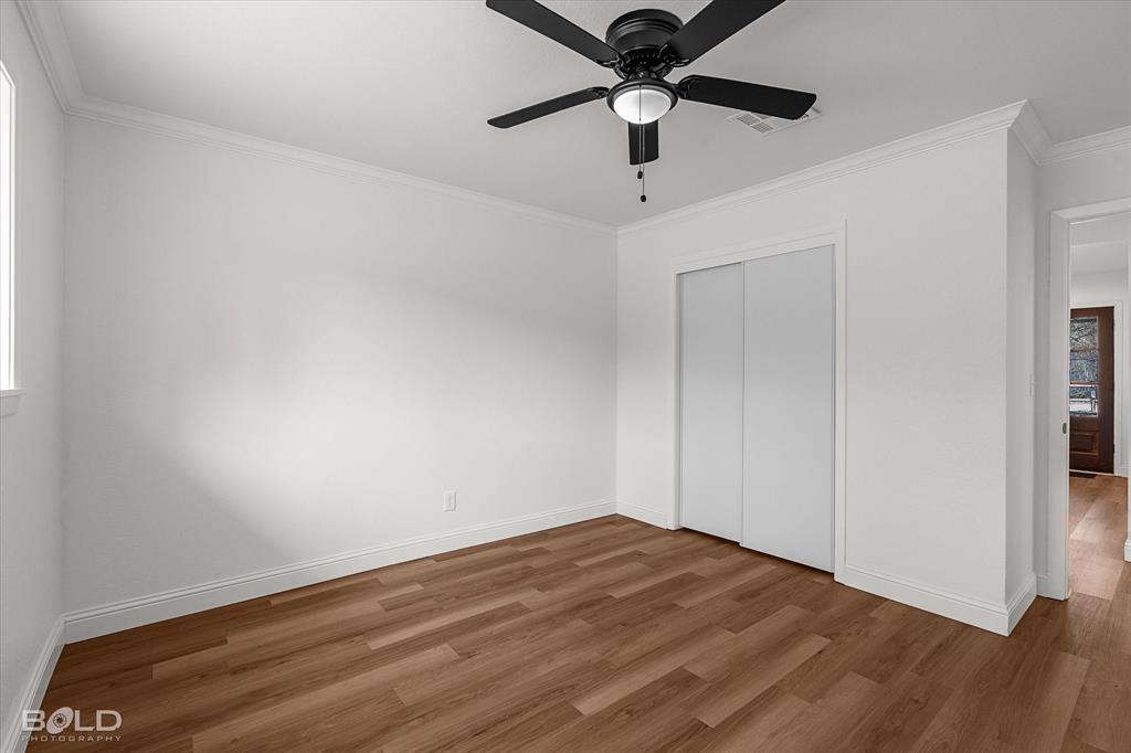 4136 Pines Road Shreveport, LA 71119 - Photo 27 of 38 Unfurnished bedroom featuring ornamental molding, wood finished floors, a ceiling fan, and a closet