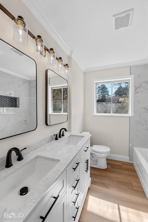 4136 Pines Road Shreveport, LA 71119 - Photo 29 of 38 Bathroom featuring double vanity, ornamental molding, light wood-style flooring, and a combined bath / shower with marble appearance
