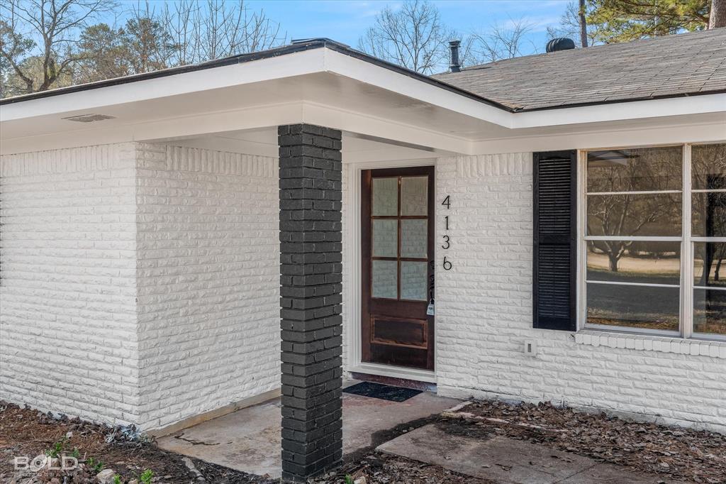 4136 Pines Road Shreveport, LA 71119 - Photo 38 of 38 Doorway to property with brick siding and roof with shingles