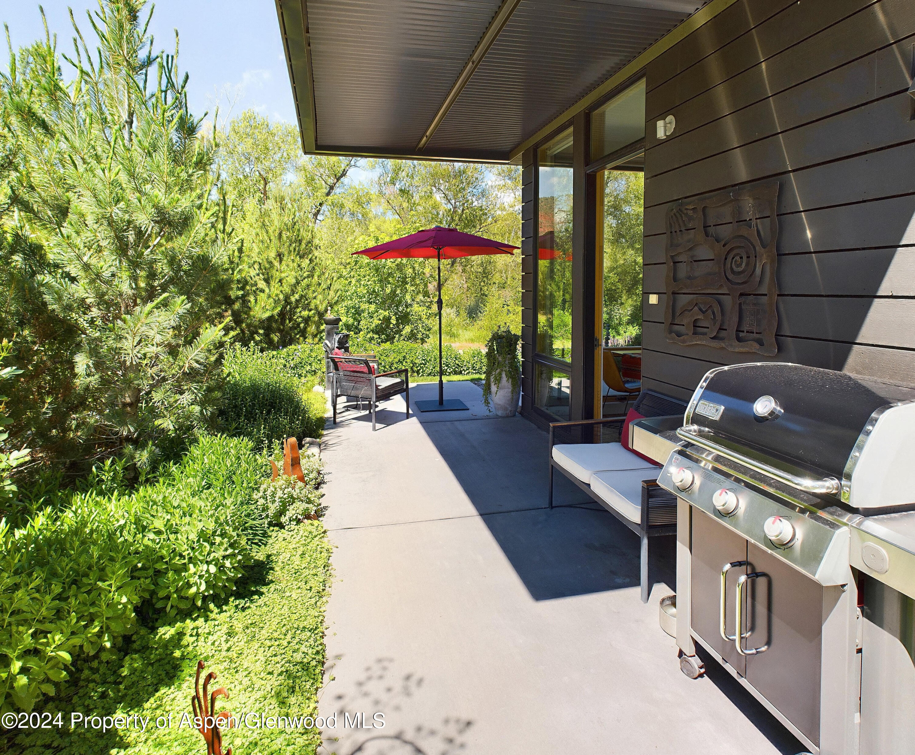 100 Evans Road, Unit 105 Basalt, CO 81621 - Photo 18 of 20 a backyard of a house with table and chairs under an umbrella