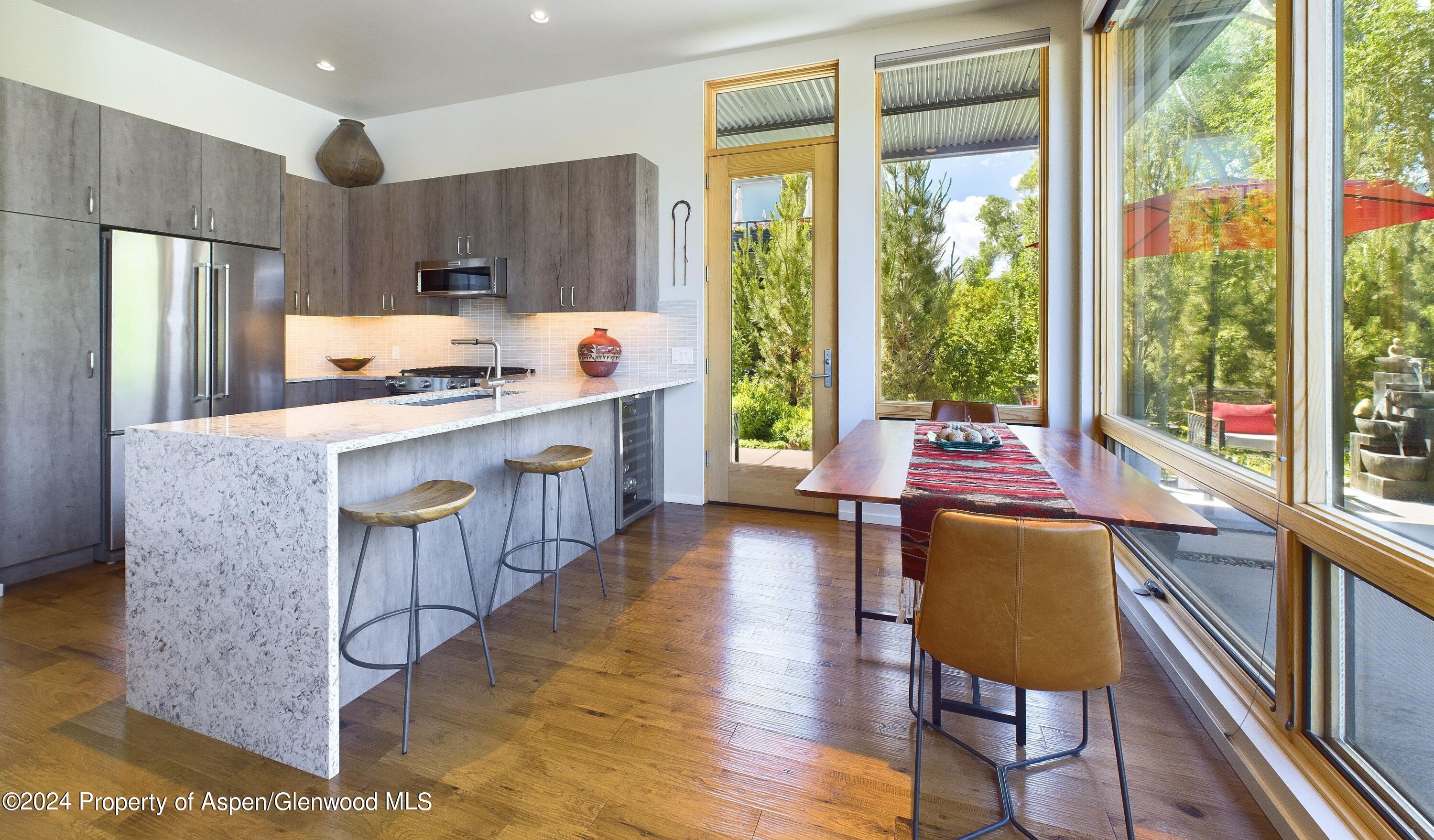100 Evans Road, Unit 105 Basalt, CO 81621 - Photo 6 of 20 a kitchen with kitchen island a large window a sink and a refrigerator
