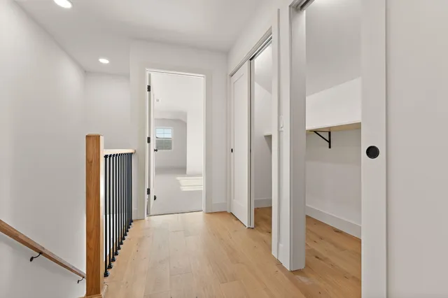 an empty room with windows and ceiling fan