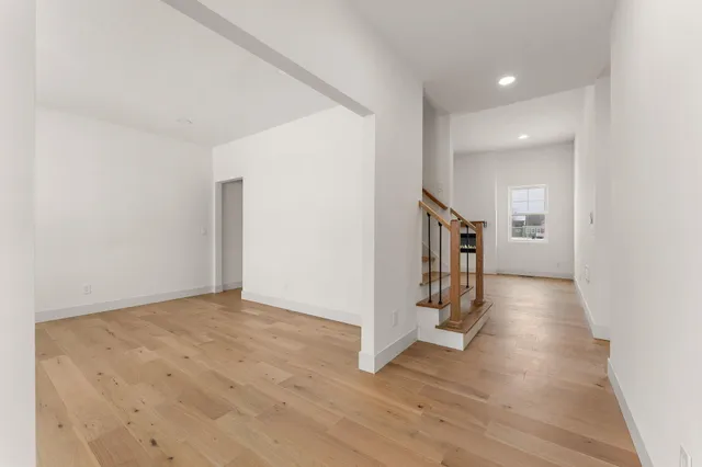 a view of a hallway with wooden floor and staircase