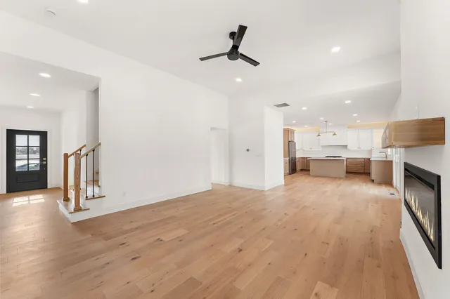 a view of empty room with wooden floor and window