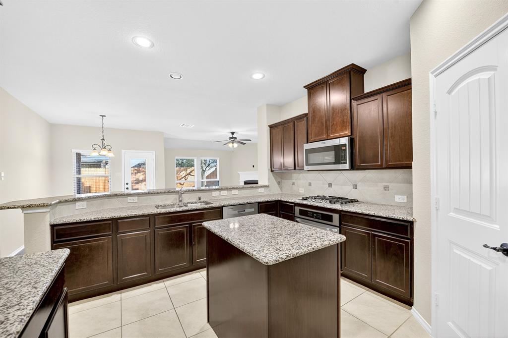 217 Rugby Lane McKinney, TX 75072 - Photo 13 of 40 a kitchen with a sink and stove