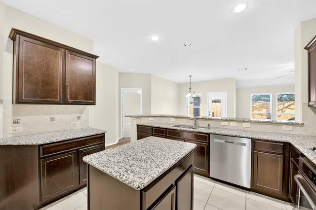 a kitchen with granite countertop stove sink and cabinets