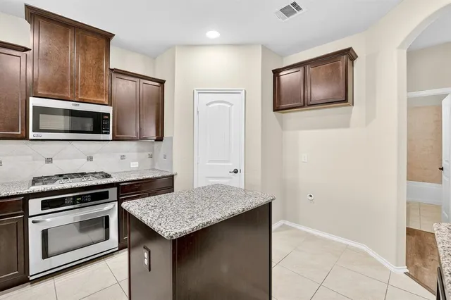 a kitchen with stainless steel appliances a stove microwave and refrigerator