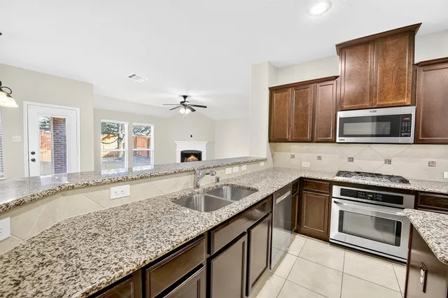 a kitchen with stainless steel appliances granite countertop a sink stove and microwave