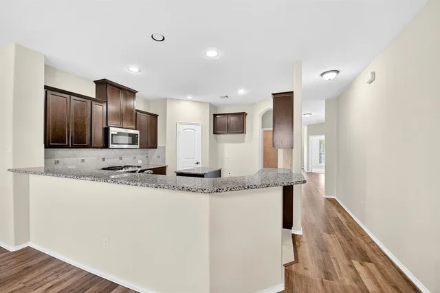 a kitchen with stainless steel appliances granite countertop a sink and a refrigerator
