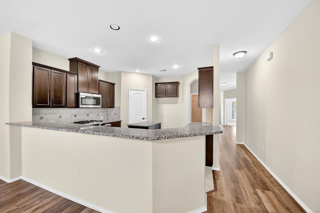 217 Rugby Lane McKinney, TX 75072 - Photo 19 of 40 a kitchen with stainless steel appliances granite countertop a sink and a refrigerator
