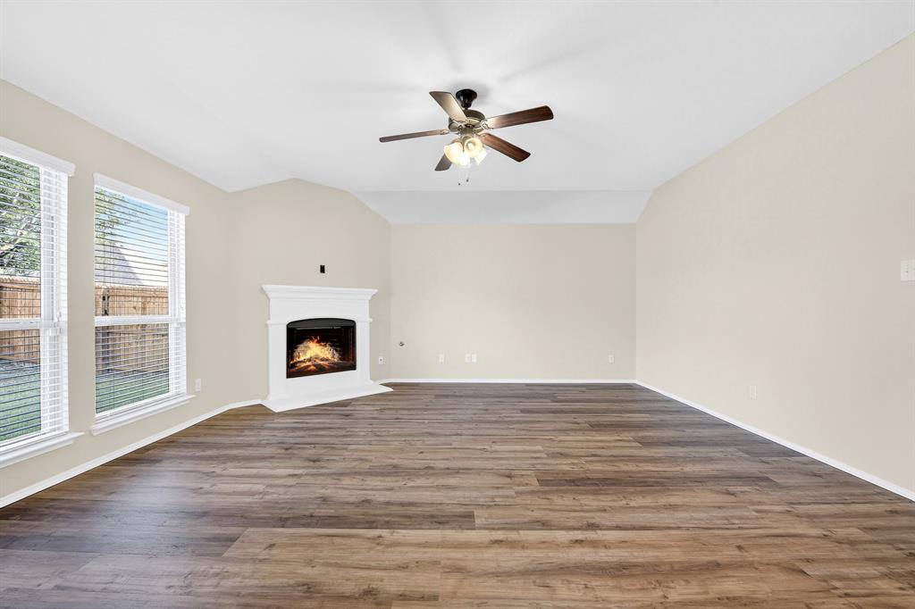 217 Rugby Lane McKinney, TX 75072 - Photo 23 of 40 a view of an empty room with wooden floor fireplace and a window