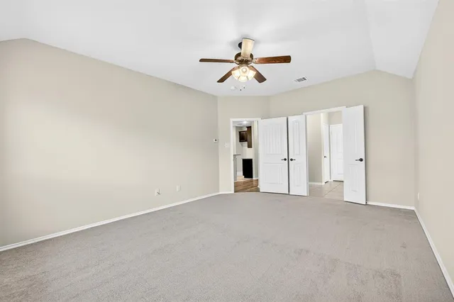 an empty room with closet and windows