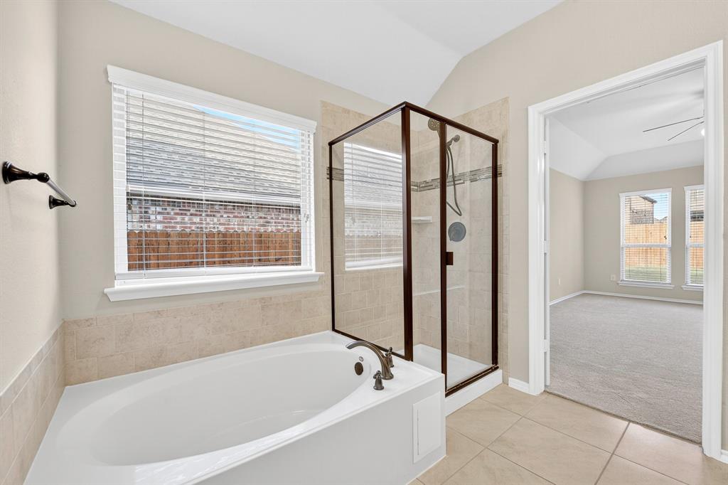 217 Rugby Lane McKinney, TX 75072 - Photo 32 of 40 a bathroom with a bathtub and a shower