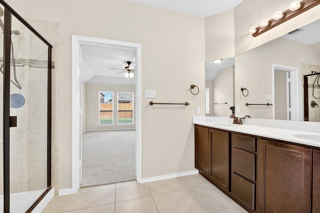 217 Rugby Lane McKinney, TX 75072 - Photo 33 of 40 a spacious bathroom with a double vanity sink a mirror and a shower