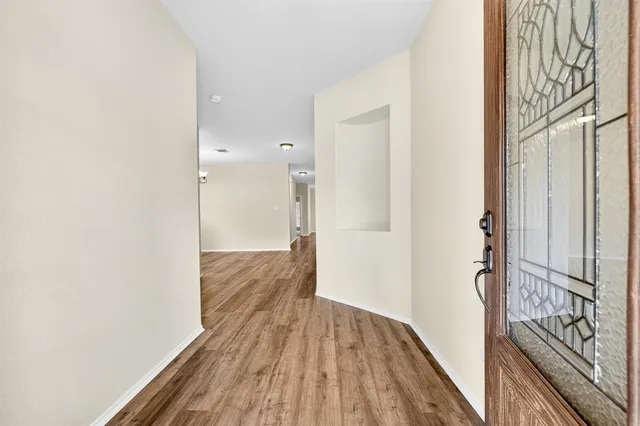 a view of a hallway with wooden floor and staircase