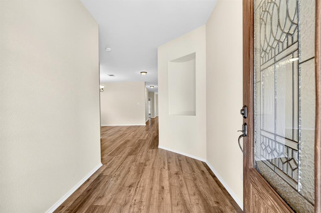 217 Rugby Lane McKinney, TX 75072 - Photo 5 of 40 a view of a hallway with wooden floor and staircase