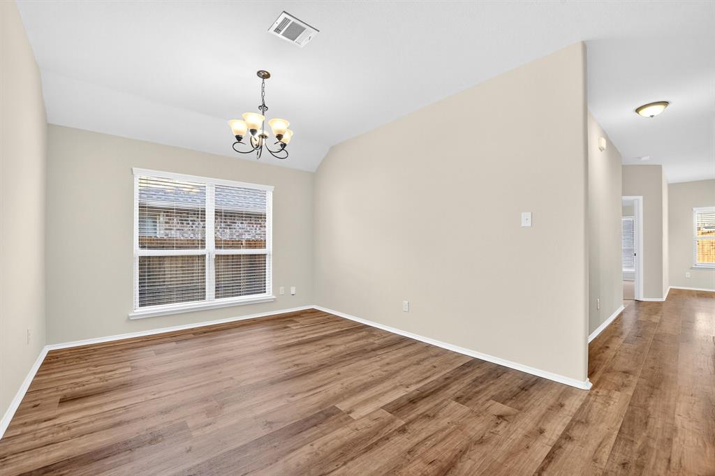 217 Rugby Lane McKinney, TX 75072 - Photo 10 of 40 a view of an empty room with wooden floor and a window