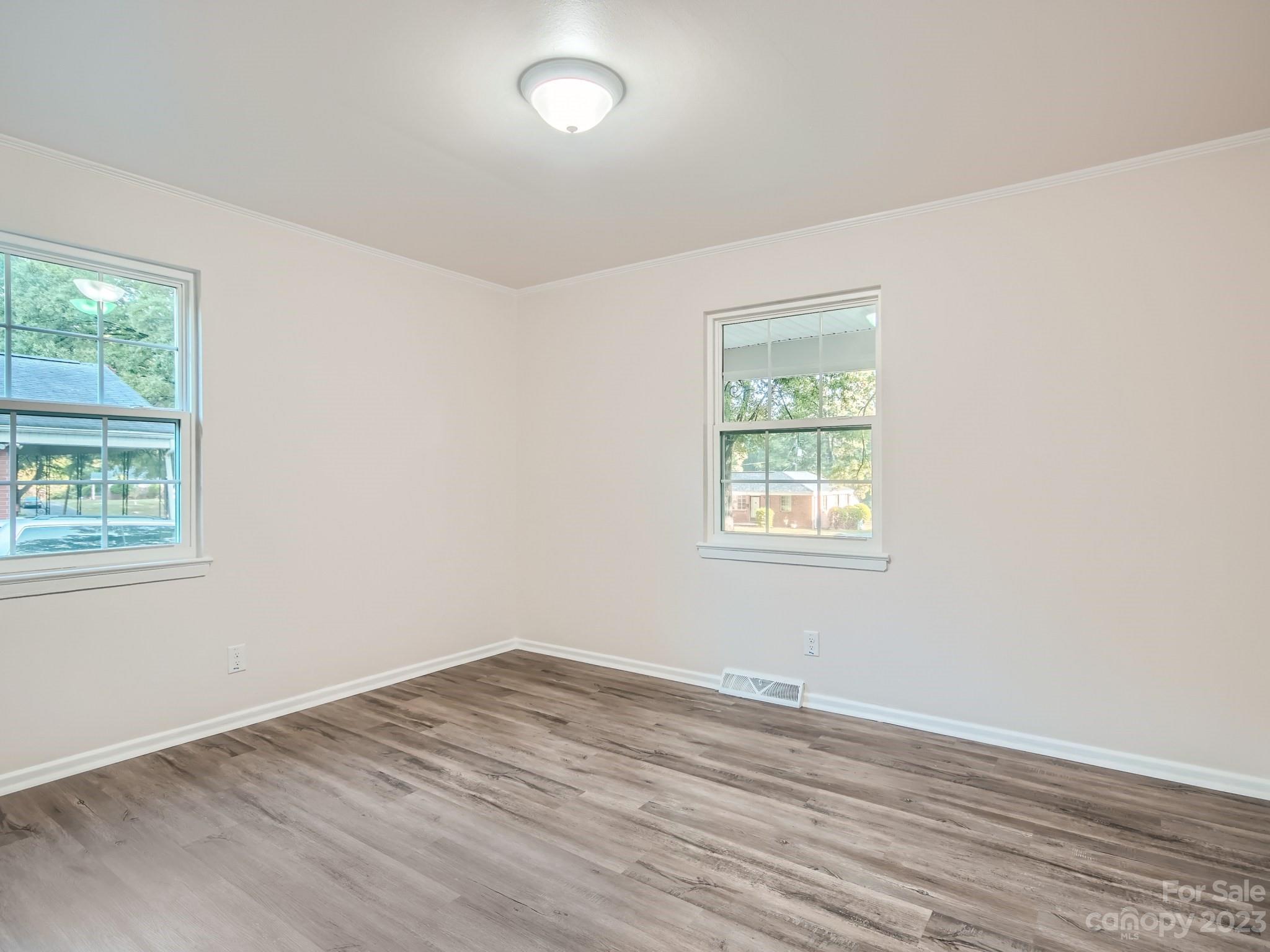 3219 Minnesota Road Charlotte, NC 28208 - Photo 6 of 11 an empty room with wooden floor and windows