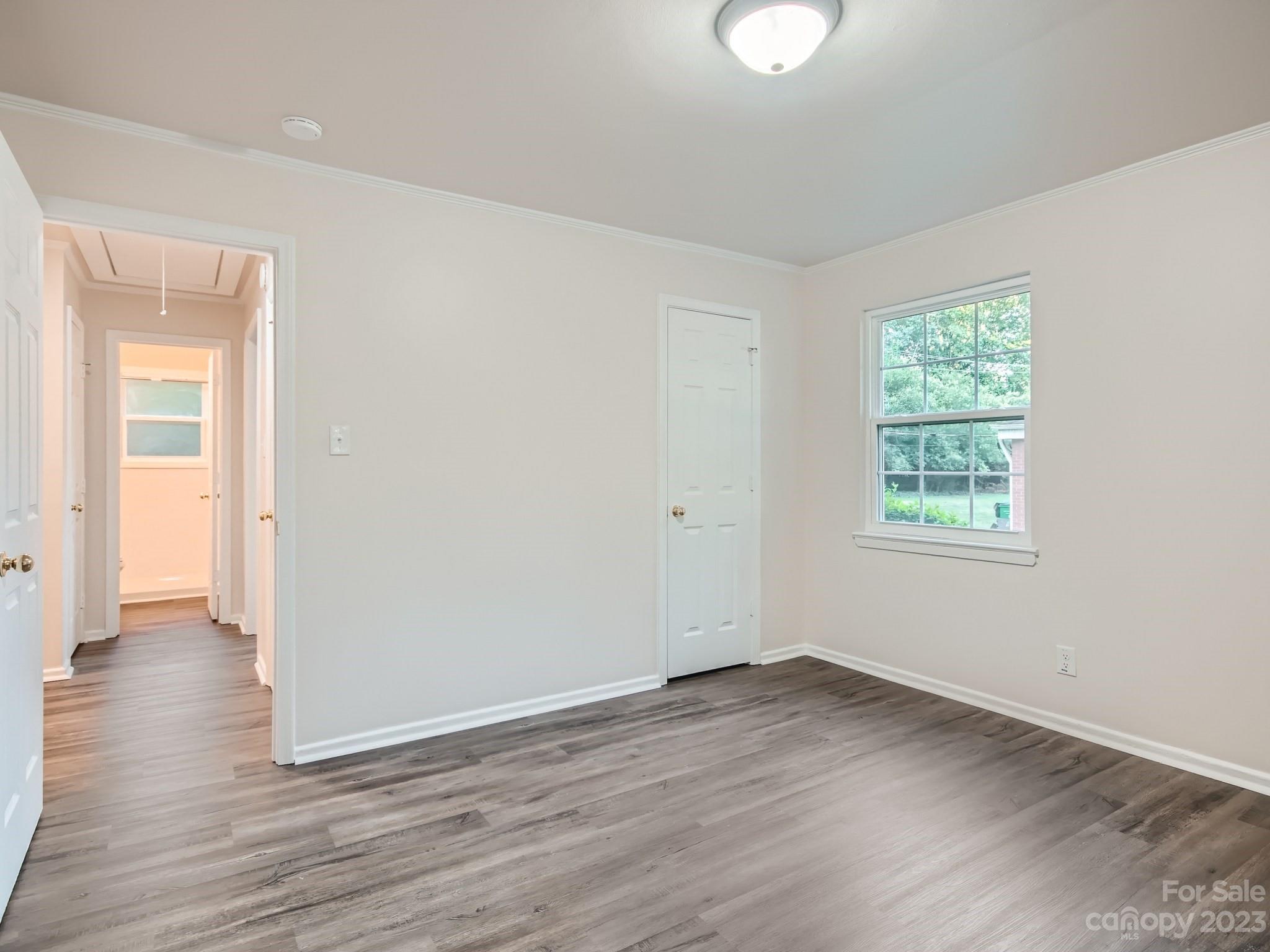 3219 Minnesota Road Charlotte, NC 28208 - Photo 7 of 11 an empty room with wooden floor and windows