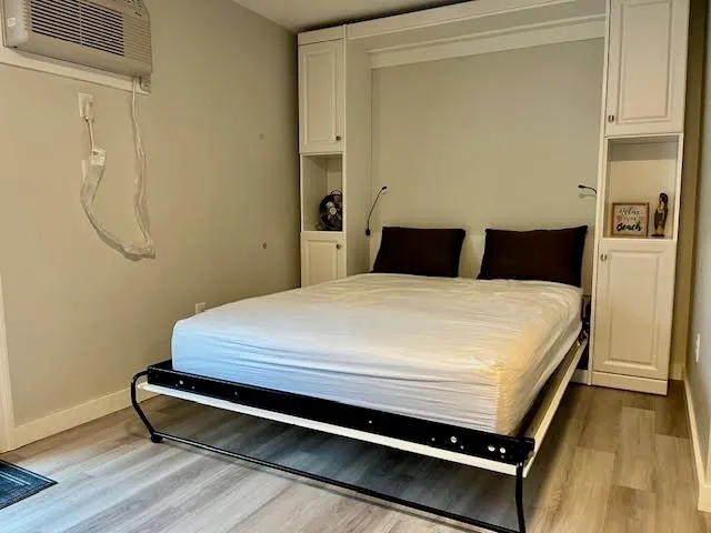 a bedroom with a bed and wooden floor