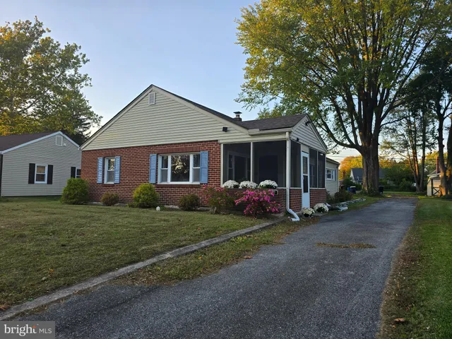 a view of a yard in front of a house with large trees