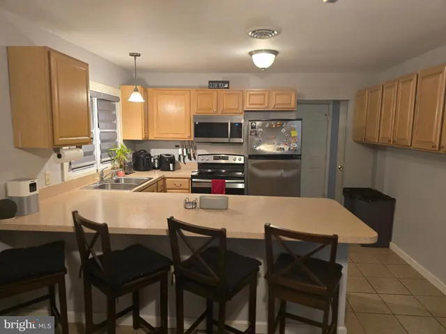 a kitchen with a dining table chairs and refrigerator