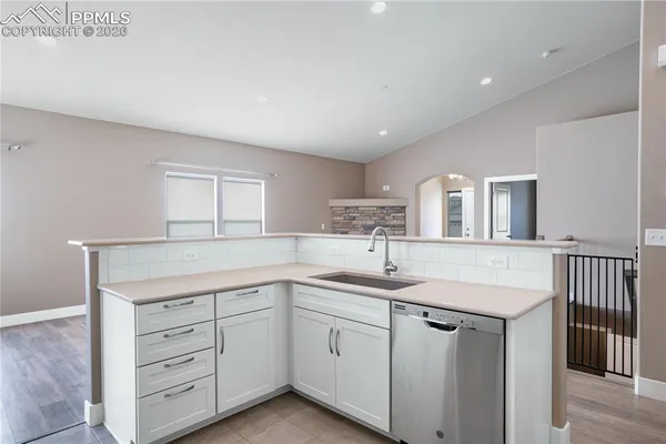 a kitchen with cabinets stainless steel appliances a sink and a window