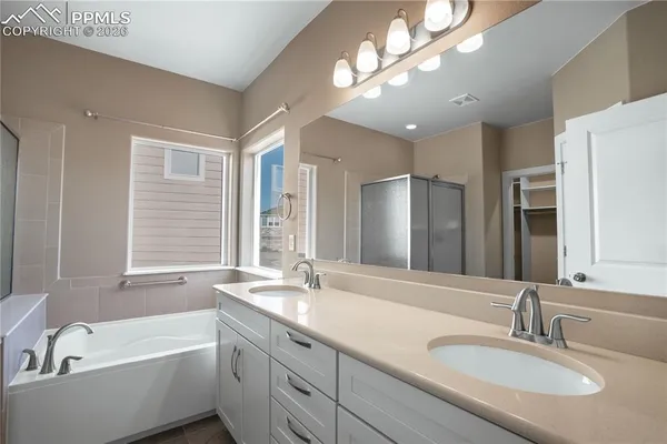 a bathroom with a tub double sink and a mirror