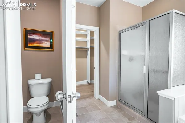 a bathroom with a toilet and a shower