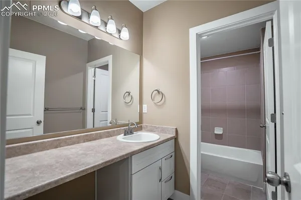 a bathroom with a sink a tub and a mirror