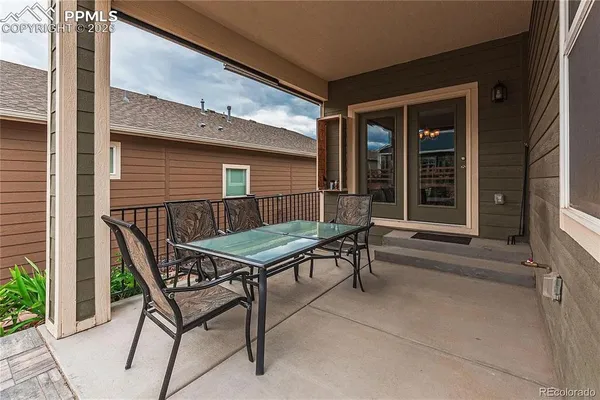 a backyard of a house with barbeque oven table and chairs