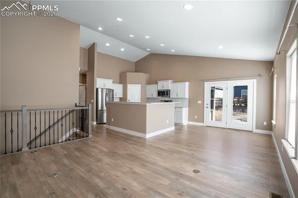 a view of a kitchen with wooden floor and a window