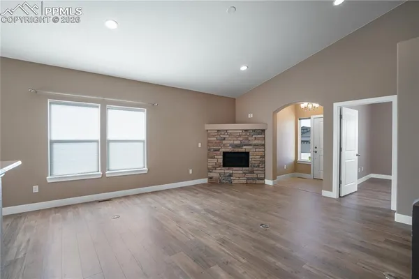 an empty room with wooden floor and a fireplace