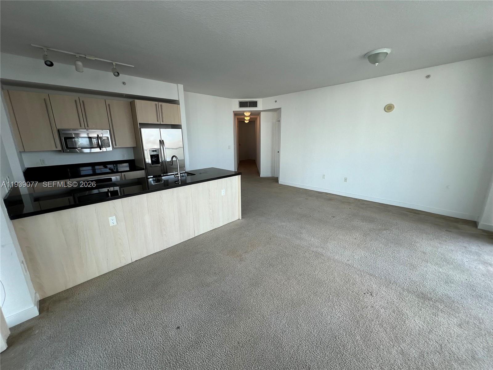 79 Southwest 12th Street, Unit 1112S Miami, FL 33130 - Photo 3 of 9 a kitchen with granite countertop white cabinets and white appliances