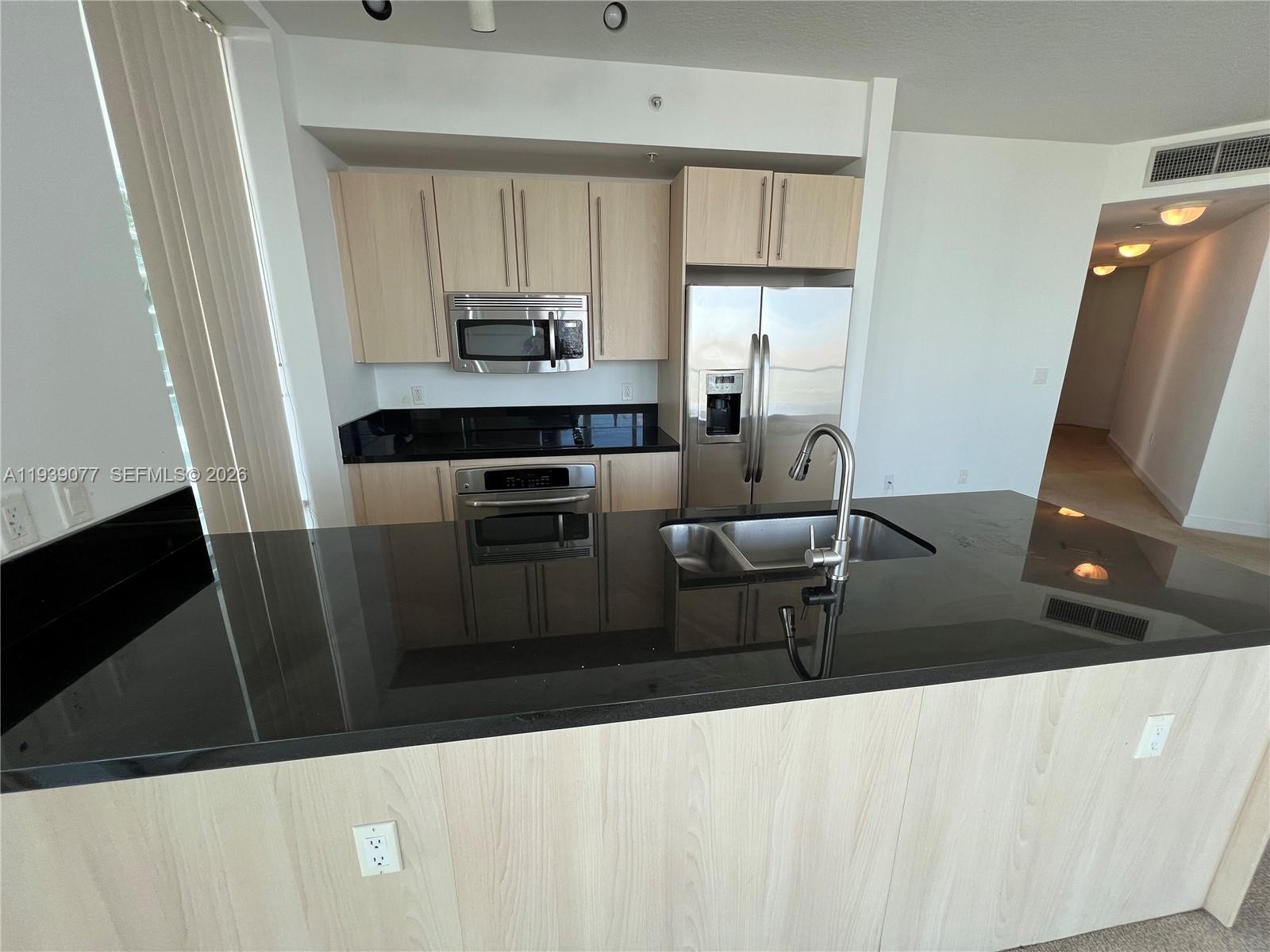79 Southwest 12th Street, Unit 1112S Miami, FL 33130 - Photo 4 of 9 a living room with stainless steel appliances furniture a sink a window and wood floor