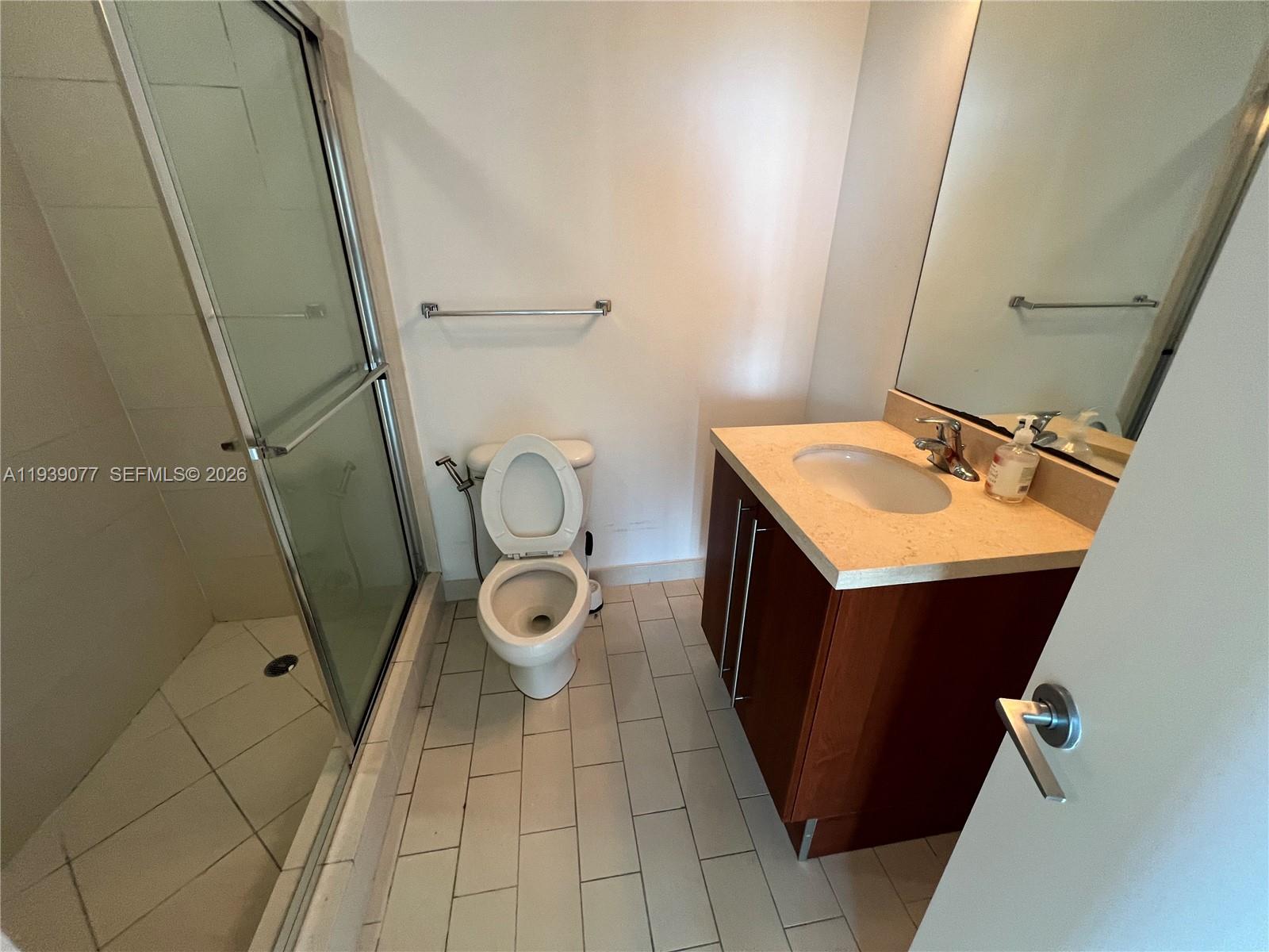79 Southwest 12th Street, Unit 1112S Miami, FL 33130 - Photo 6 of 9 a bathroom with a sink a toilet and a mirror