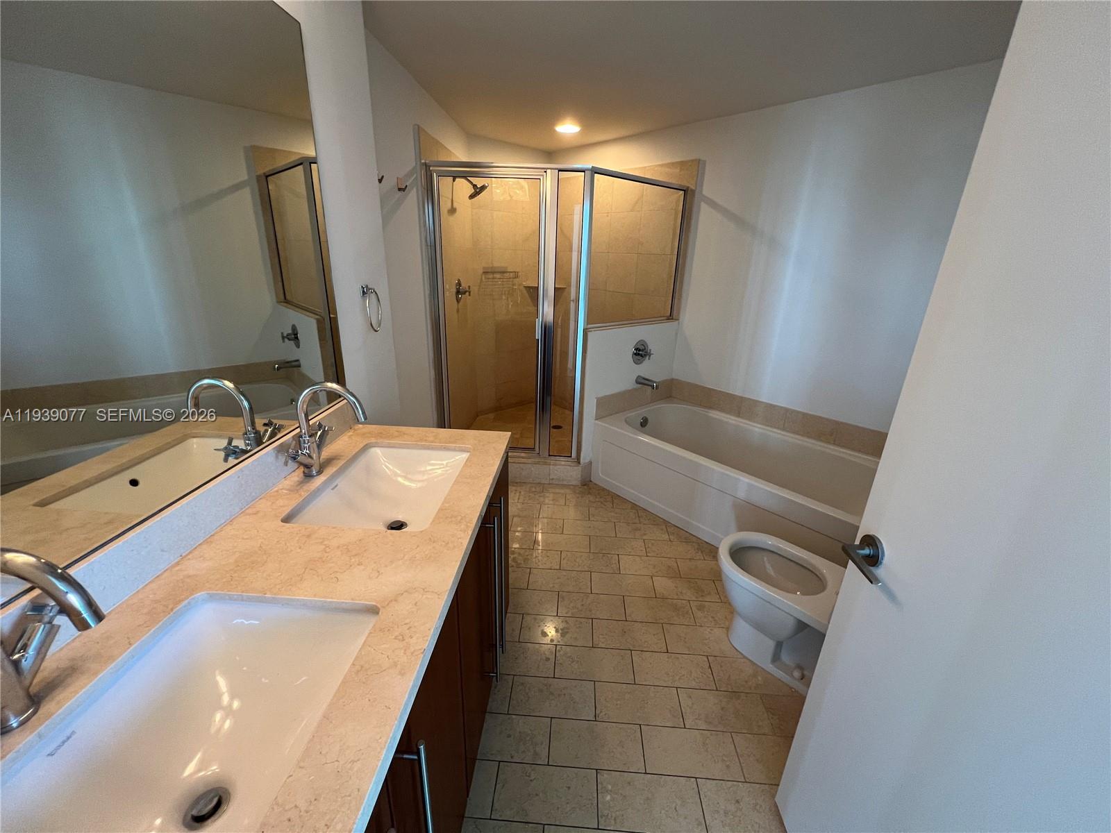 79 Southwest 12th Street, Unit 1112S Miami, FL 33130 - Photo 8 of 9 a bathroom with a tub sink and mirror