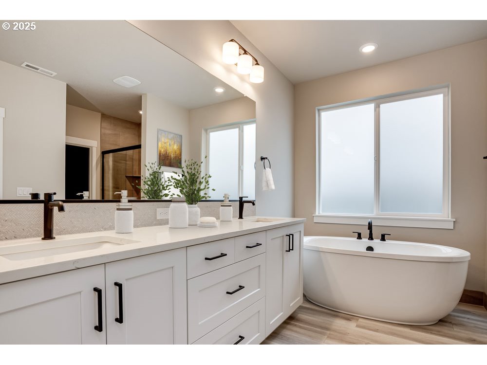 4531 South 39th Drive Ridgefield, WA 98642 - Photo 6 of 8 a bathroom with a double vanity sink a mirror and a bathtub